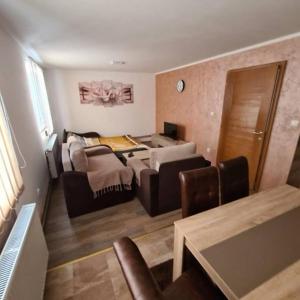 uma sala de estar com um sofá e uma mesa em Apartman Popadić em Nova Varos