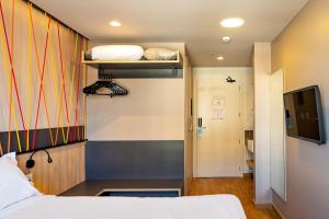 um quarto com uma cama e uma televisão num quarto em ibis Styles Porto Alegre Moinhos de Vento em Porto Alegre