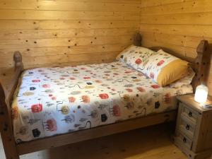 a bed in a room with a wooden wall at The Chalet @ Giltar Grove Country House in Tenby