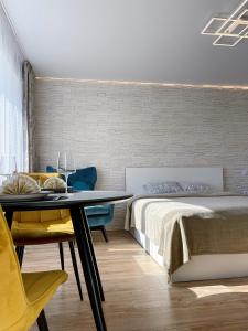 een slaapkamer met een bed en een tafel en stoelen bij Park & Beach Area Apartment in Liepāja