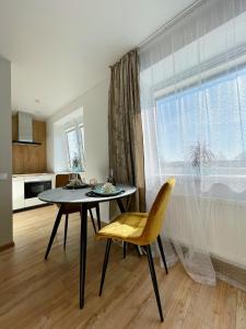 a dining room with a table and chairs and a window at Park & Beach Area Apartment in Liepāja