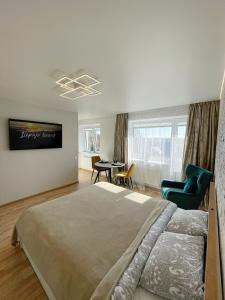 a bedroom with a large bed and a table and chairs at Park & Beach Area Apartment in Liepāja