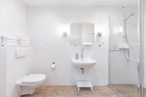 Hugin في هوسوم: حمام أبيض مع مرحاض ومغسلة