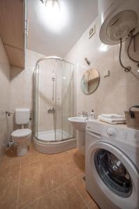 y baño con ducha, aseo y lavadora. en Apartman J&I en Kotor