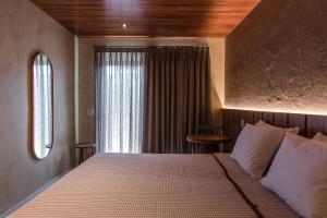 um quarto com uma cama grande e uma janela em Vila Sal Boutique Noronha em Fernando de Noronha