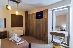 a room with a bed and a tv and a mirror at The Bazaar Refuge in historical centre in Preveza +6 photos