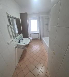 a bathroom with a sink and a toilet and a tub at Monteurwohnung Uettinge in Uettingen