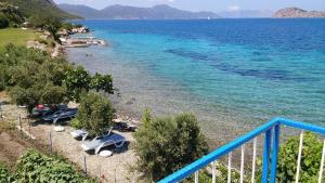 a beach with a group of chairs and the water at Mavi Akvaryum Pension in Sogut