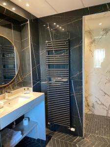 een badkamer met een wastafel en een douche bij Hotel Bristol in Mulhouse
