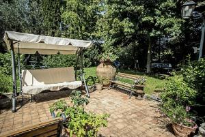 eine Bank und einen Regenschirm in einem Garten in der Unterkunft Relais de Charme - B&B Short Lets La Casa di Francesca in Sant’Agata Li Battiati 