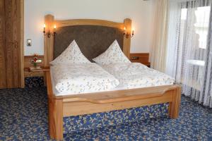 1 dormitorio con cama de madera y almohadas en Gästehaus Nigg, en Eisenberg