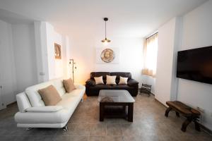 salon z kanapą i telewizorem w obiekcie Duplex 8 Caños w mieście Ronda