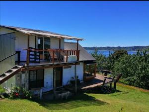 a house with a deck and a view of the water at Quemchi Cabaña in Quemchi