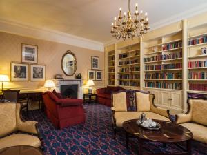 sala de estar con muebles y lámpara de araña. en Macdonald Leeming House, en Watermillock