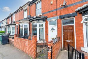 a red brick building with a white door at Fantastic 3 Bedroom House *Free Parking* in Wolverhampton