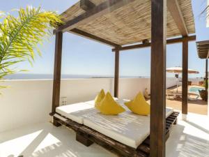 un porche con una cama con almohadas amarillas en Villa San Blas Chillout - Princesa Yaiza 7 by Dolores, en Tías