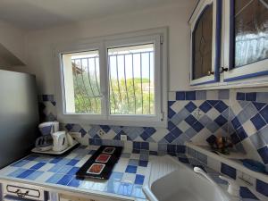 una cocina con azulejos azules y blancos en la encimera en Villa 78 m2 - Au Chant des Cigalous, en Six-Fours-les-Plages