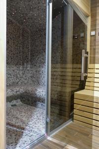 una doccia con porta in vetro in bagno di Drvena Kuca RUŽA a Kopaonik