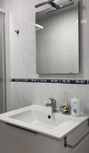 a white sink in a bathroom with a mirror at Apartamento el Cau, acogedor y cerca del Montseny in Arbúcies