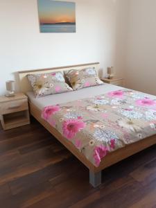 een slaapkamer met een bed met roze bloemen erop bij Karlo in Poreč
