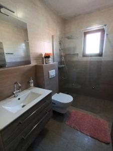 uma casa de banho com um lavatório, um WC e uma janela. em Karlo em Porec