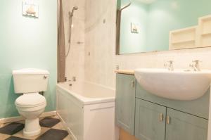a bathroom with a sink and a toilet and a tub at Central Cheltenham, Regency Apartment with PARKING, Cavalier Suite - Sleeps 6 in Cheltenham