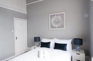 a bedroom with a white bed with blue pillows at Central Cheltenham, Regency Apartment with PARKING, Cavalier Suite - Sleeps 6 in Cheltenham