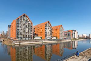 a group of buildings next to a body of water at Penthouse Aura by Q4Apartments in Gdańsk