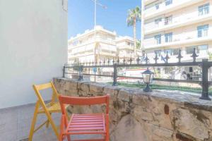 two chairs sitting on a stone wall in front of a building at 1 BedRoom Apartment Opposite Medical Center in Heraklio Town