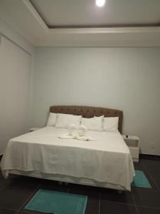 ein weißes Bett mit zwei weißen Handtüchern darauf in der Unterkunft Topazzo Hotel in Uruara
