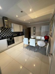 Una cocina con gabinetes blancos y una mesa y sillas. en WEST END -Stunning, 2 bedroom, main door flat with private parking, en Glasgow