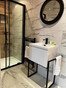 Un baño con lavabo blanco y ducha. en WEST END -Stunning, 2 bedroom, main door flat with private parking, en Glasgow