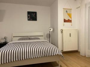 a bedroom with a bed with a black and white striped comforter at studio CHEZ TONY in Luxembourg