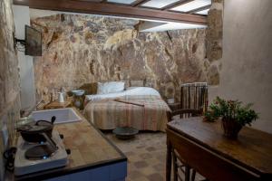a bedroom with a bed and a sink in a room at Case degli Avi 2, antico abitare in grotta in Modica