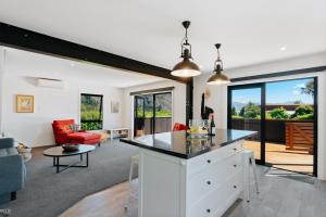 a kitchen and living room with a view of a patio at Views on Parry - Lake Hāwea Holiday Home in Lake Hawea