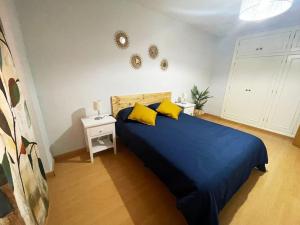 a bedroom with a blue bed with two yellow pillows at El Refugio de Yetana Centro ciudad con parking in Cartagena