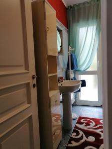 ein Bad mit einem Waschbecken, einem WC und einer Tür in der Unterkunft Casa Dana Andora in Marina dʼAndora
