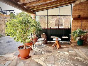 un patio con piante in vaso, panca e tavolo di Palma's Place Casanova Moradia #WIFI#POOL#RELAX a Faro