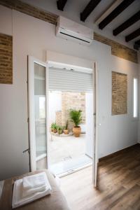 um quarto com uma porta de vidro deslizante que leva a um pátio em Alijar Casa Boutique em Castilleja de la Cuesta