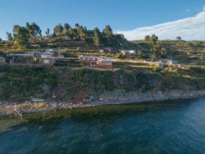 un gruppo di case su una collina vicino all'acqua di Posada de Oliver a Llachon