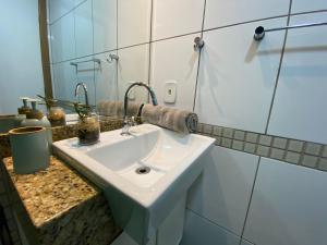 a bathroom with a white sink and a mirror at ITAPARICA BEACH 24HRS in Vila Velha