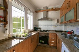a kitchen with wooden cabinets and a sink and a window at Casa de la Vega in Cúllar-Vega