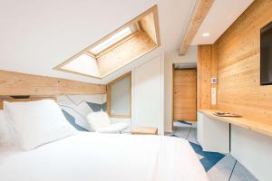 a bedroom with a white bed and a skylight at Best Western Chalet les Saytels in Le Grand-Bornand