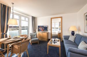 a living room with a blue couch and a table at Strandhotel Juister Hof in Juist