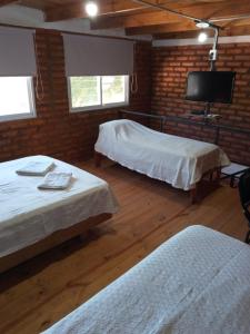 a room with two beds and a flat screen tv at Duplex Chacabuco in San Fernando del Valle de Catamarca