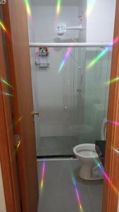 a bathroom with a toilet with rainbow lights on the floor at Lindo Flat no Residencial Maraca Beach in Porto De Galinhas