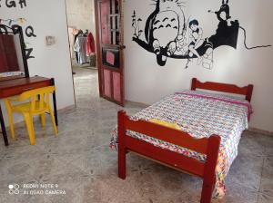a small bedroom with a bed and a desk at Casa de los Cruz in Leticia
