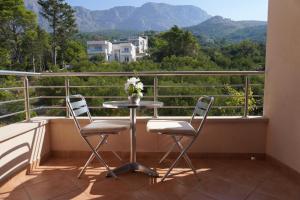 een tafel en 2 stoelen op een balkon met uitzicht bij Villa Palma in Tučepi
