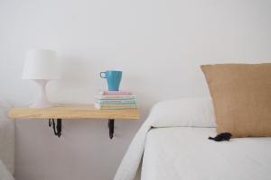 a cat sitting on a bed next to a side table at Hostal Sol in Zamora