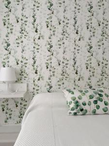 a bedroom with a wall with a floral wallpaper at Hostal Sol in Zamora